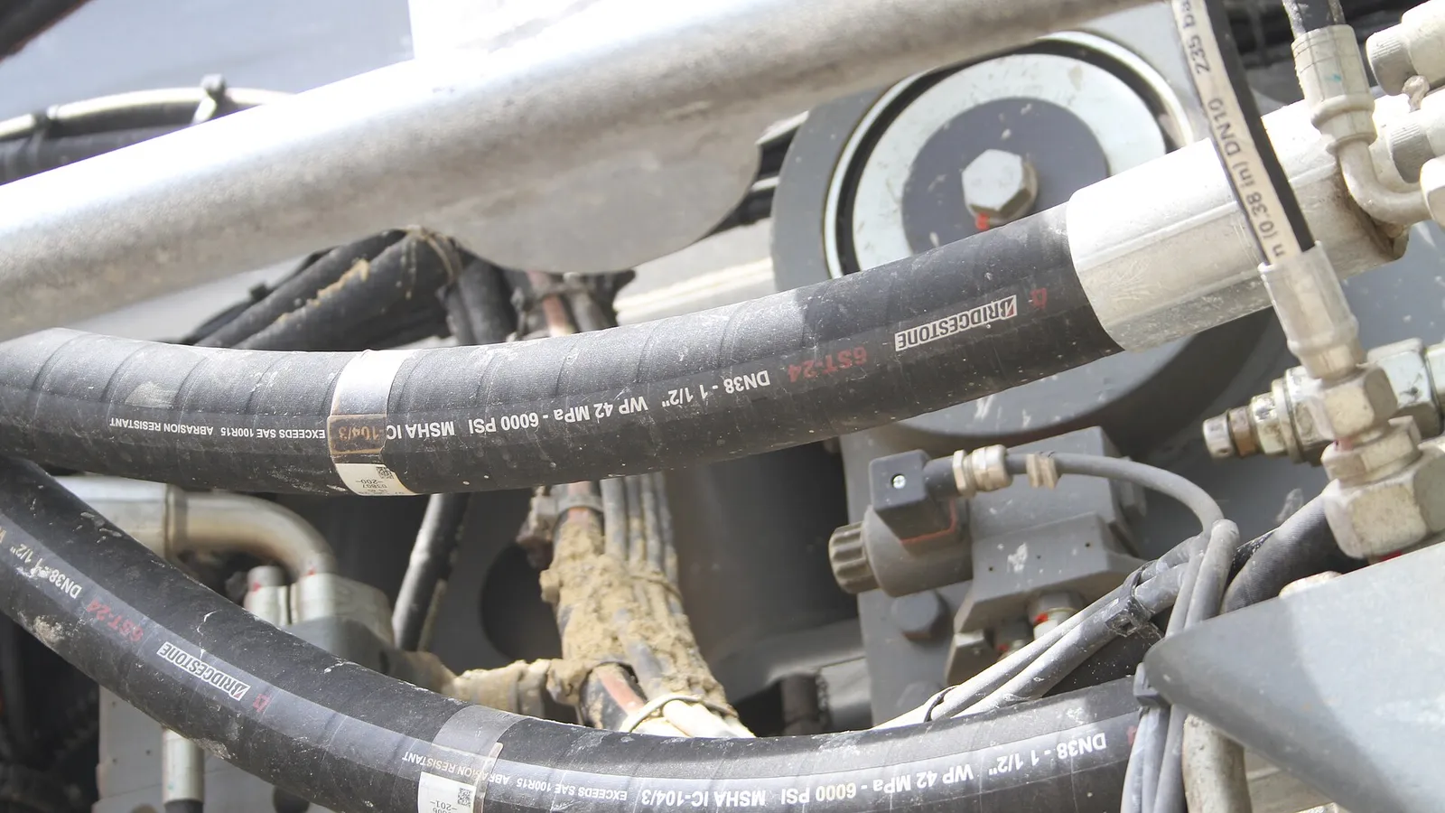 Black hydraulic hose with printed spec markings and fittings